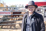 Kate Nugent stands in front of a droughtmaster bull.