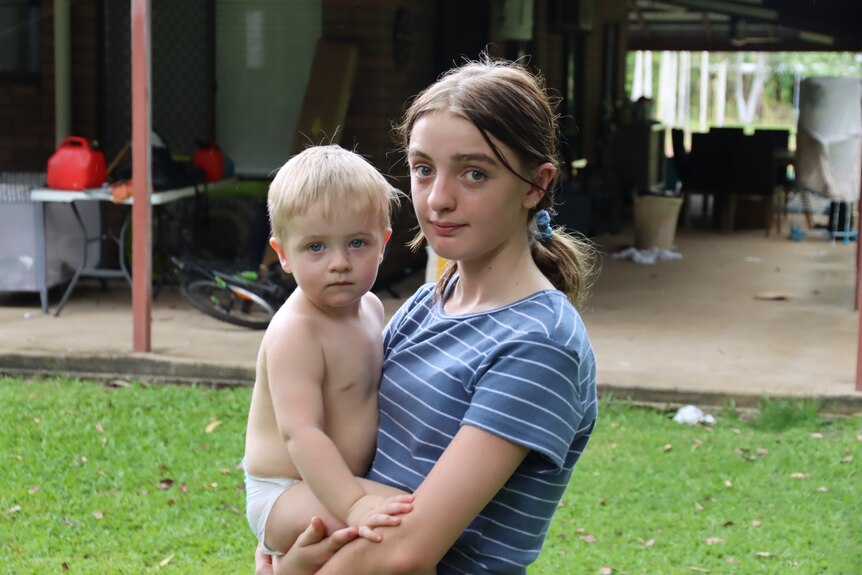 a teenage girl holding a baby