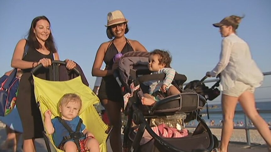 Two mothers with prams at Bondi Beach.
