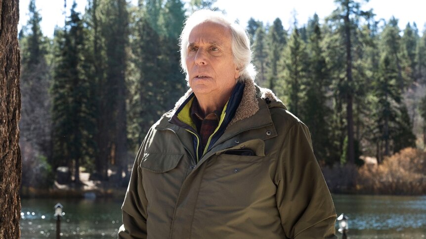 Actor Henry Winkler in character in the show Barry, an older man in a parka, looking bereft, out in the wild