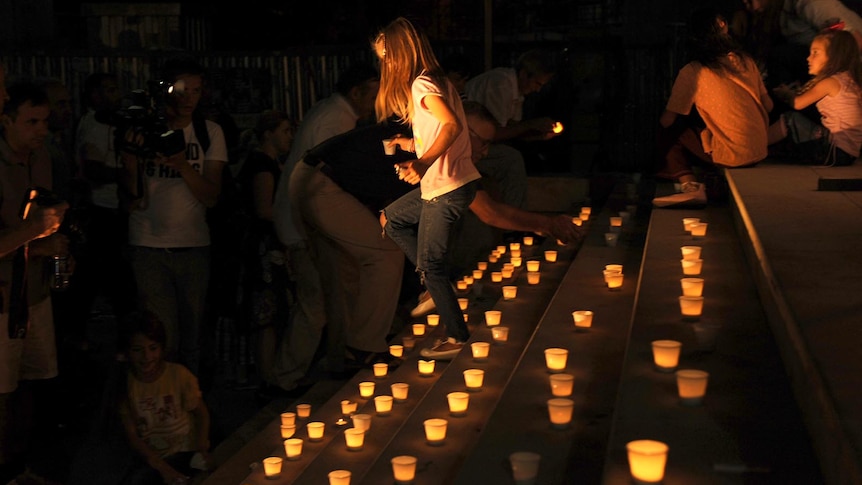 A young girl walks through candles lit to pay tribute to the victims of the 9/11 attacks in Kosovo