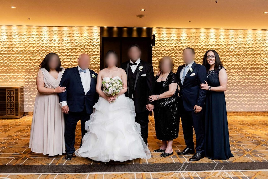 Abdelmalek poses in a gown as part of a formal family wedding photo.