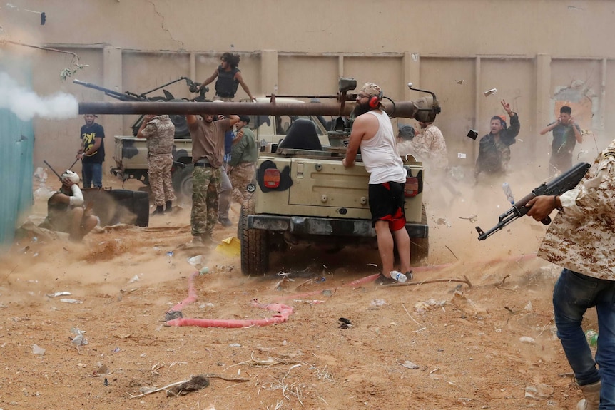 Libyan fighters fires a 105 mm recoilless rifle during clashes.