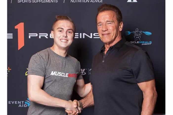 A young man shaking hands with an older man, both smiling