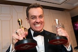 Grant Denyer holds up his silver and gold logies