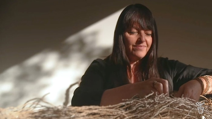 Woman weaving plant materials