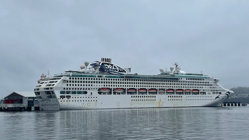 A big cruise ship is seen docked in Hobart under grey skies.