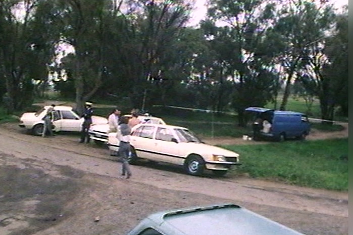 Police examine in daylight the scene where Rodney Mitchell's body was found.