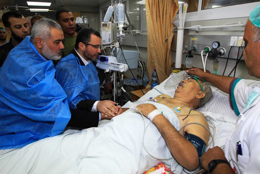 Ismail Haniyeh and Hisham Kandil visit a victim of an Israeli air strike in hospital in Gaza City.