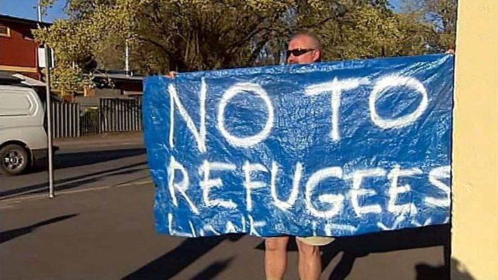 A man holds a sign outside the Woodside town hall at Inverbrackie in the Adelaide Hills, October 21, 2010. (ABC TV)