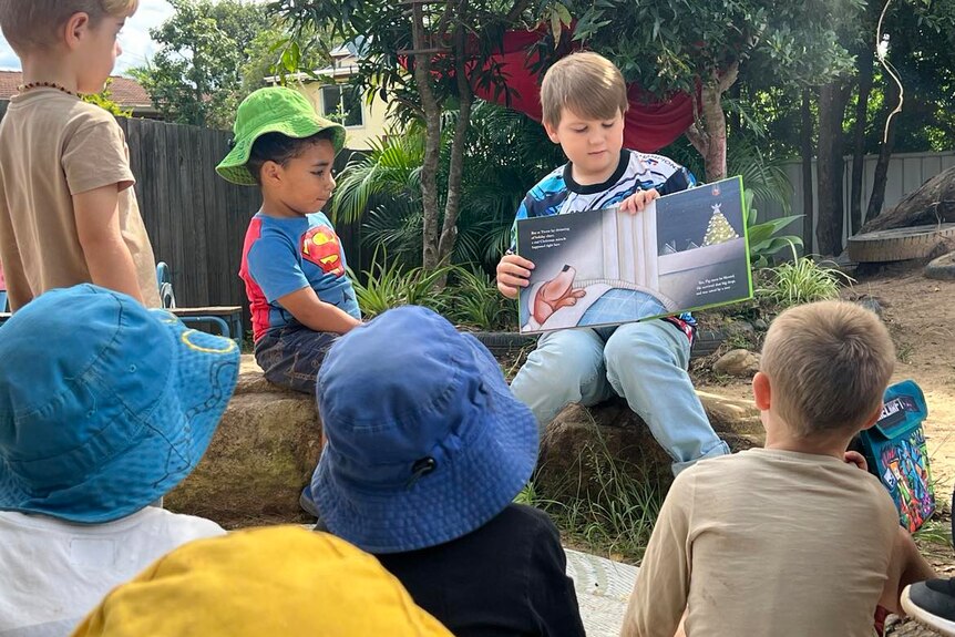 liam reading to a group of preschool children