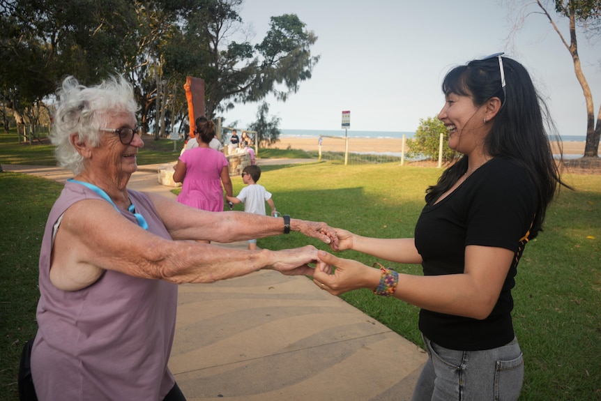 Two women dance in a park