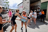 Women handling bottles of water from a truck