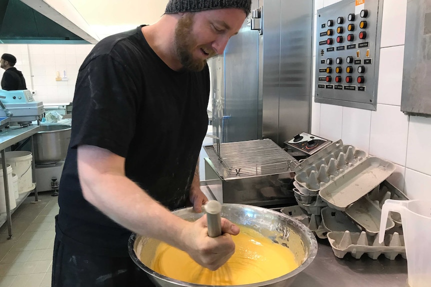 Caleb Evans mixing up batter in his hangar bakery.