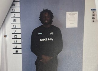 Man stands looking at camera with arms crossed