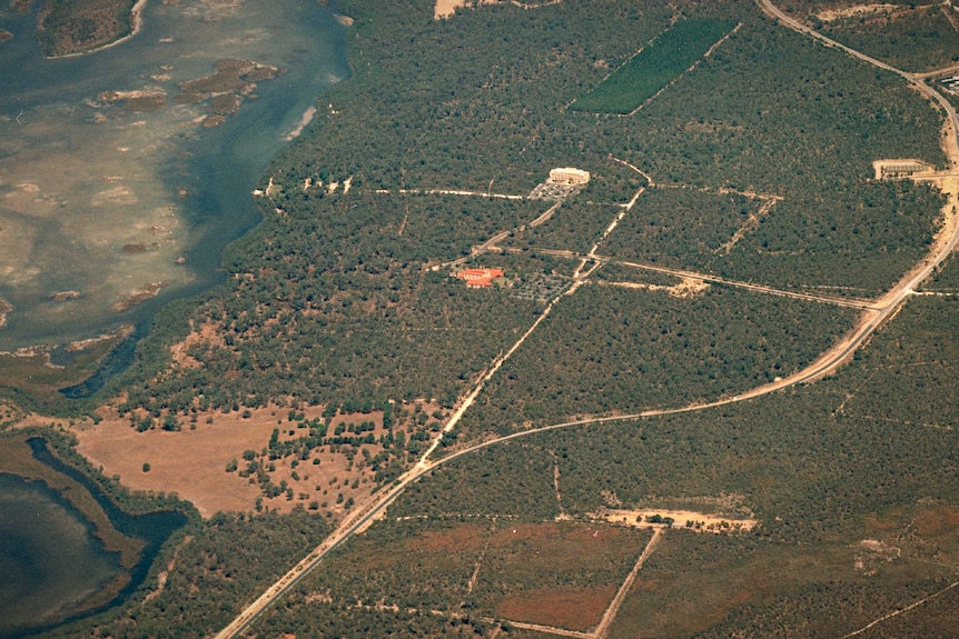 An aerial photo showing a building and access roads surrounded by bushland.