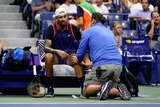 Nick Kyrgios gives a grimace as he talks to a trainer during a medical time-out at the US Open.