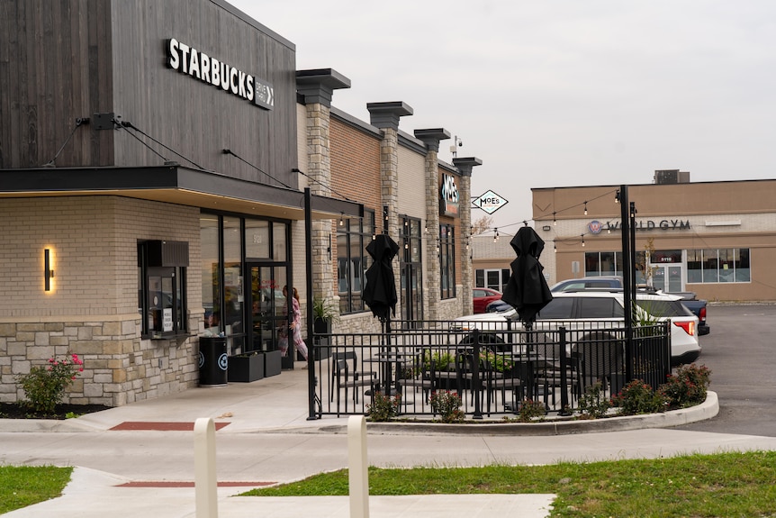 A sign on a building displays the words Starbucks.