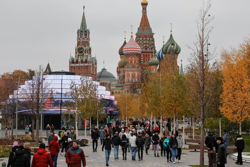 Crowds of people rugged up in winter coats walking through Zarydye Park in central Moscow.
