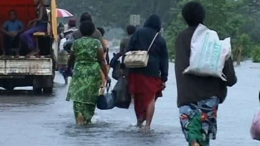 people walking in flood waters in fiji