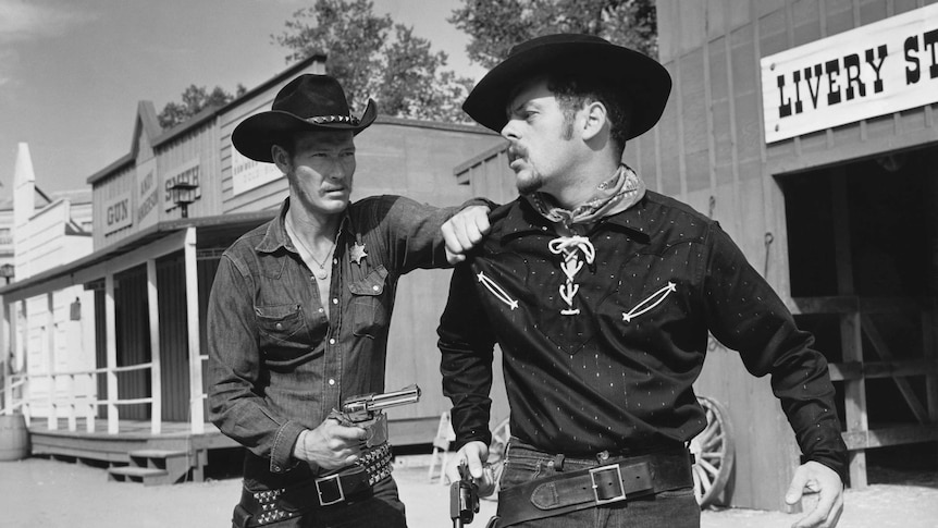 Sheriff pointing a pistol at a cowboy.
