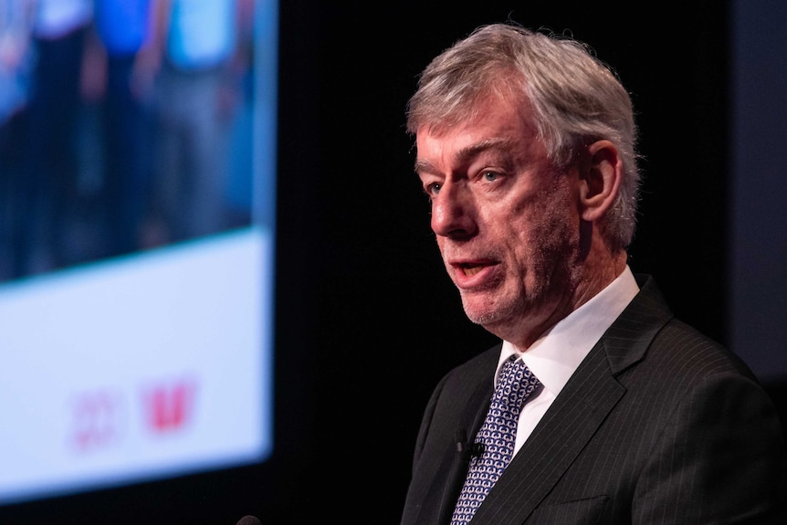 A close up of Westpac Chairman Lindsay Maxsted giving a speech at a podium with a screen behind him