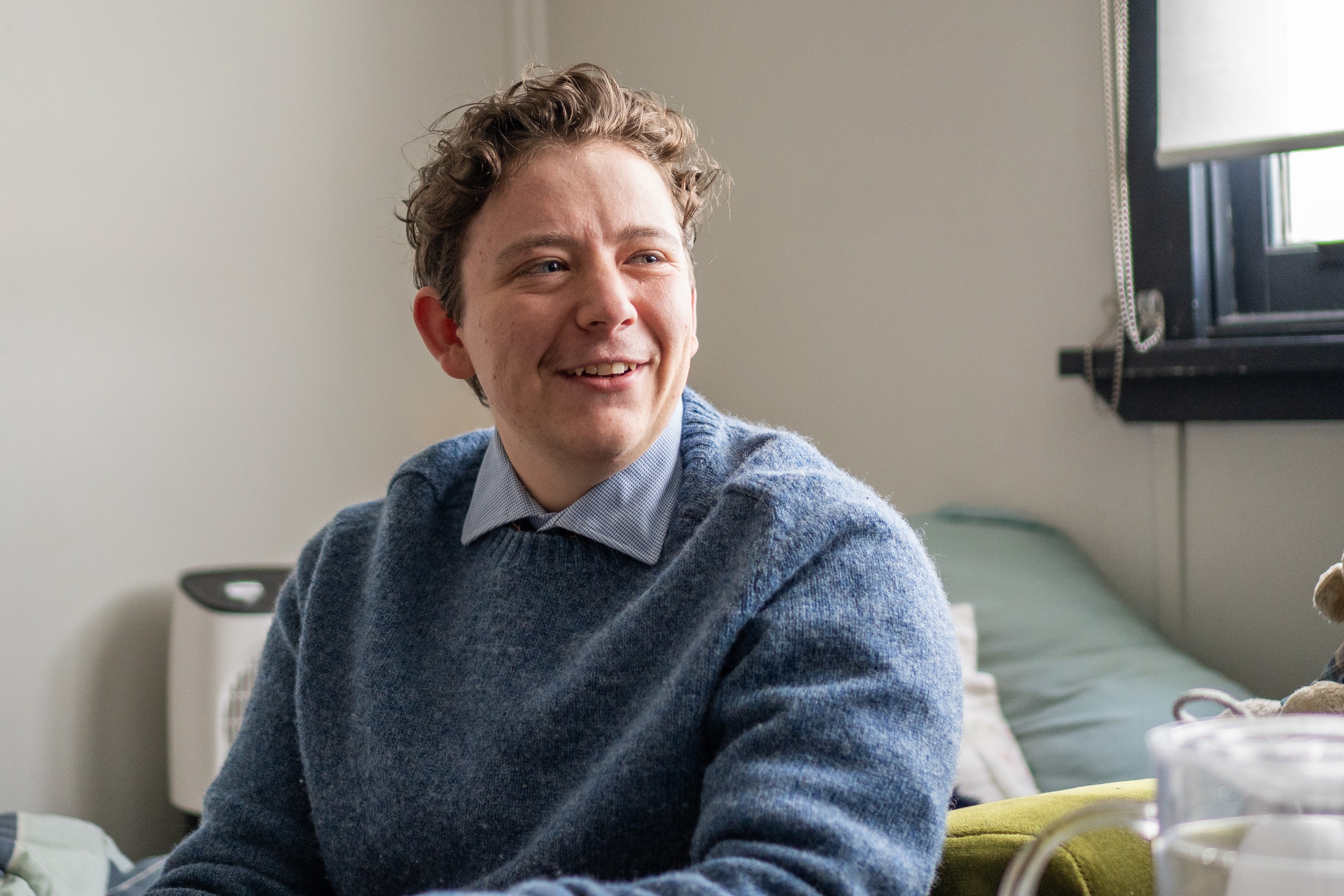 A smiling young man looks at someone off-camera.