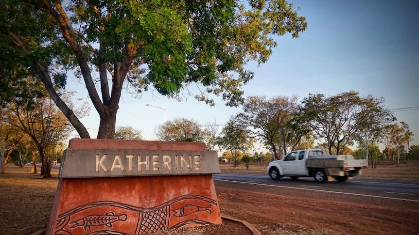 A ute drives past the entrance to Katherine, NT.