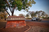 A ute drives past the entrance to Katherine, NT.