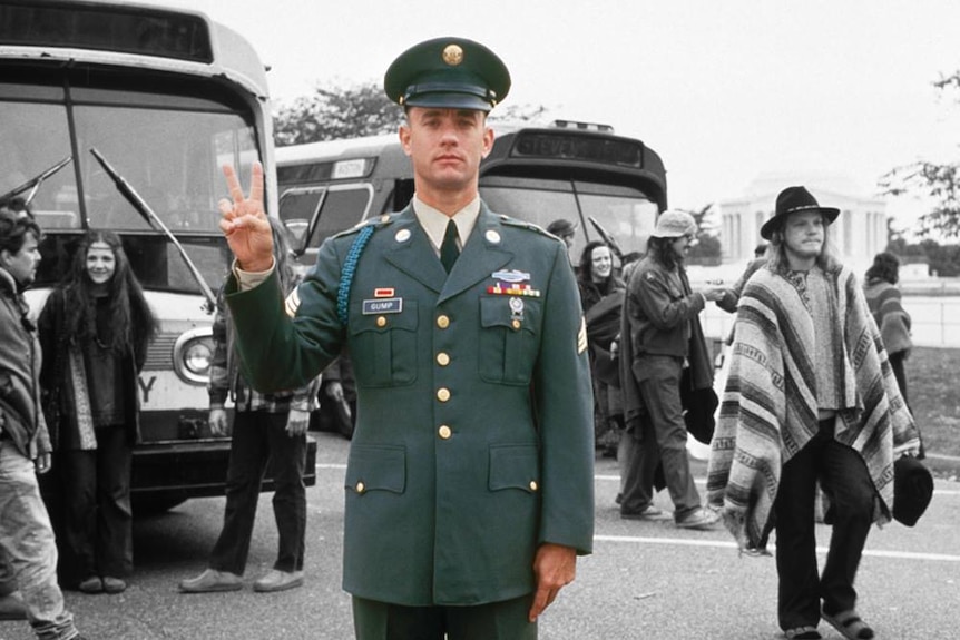 Forrest Gump gives in the peace sign in his army uniform