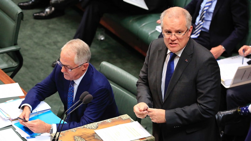 Treasurer Scott Morrison speaks as Prime Minister Malcolm Turnbull looks at his phone during Question Time