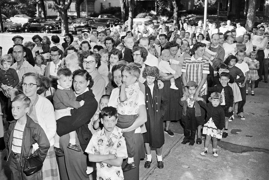 Parents and children wait outside of a public school in to get the polio vaccine, 1953.