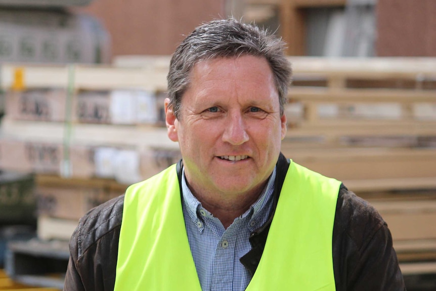 Ralph Doedens stands in a warehouse wearing a high visibility vest.