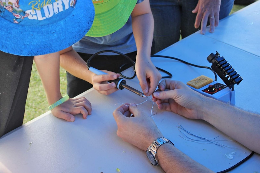 Children's hands soldering electronic circuit components