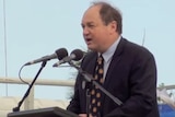 A shot of David Archibald at a podium speaking into a microphone.