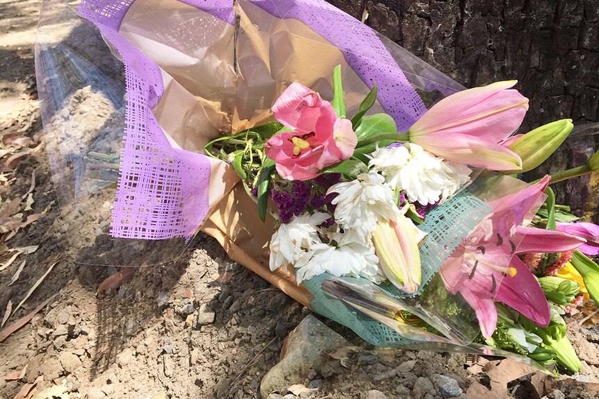 Flowers placed against a tree in honour of Toyah Cordingley at Wangetti Beach, north of Cairns.