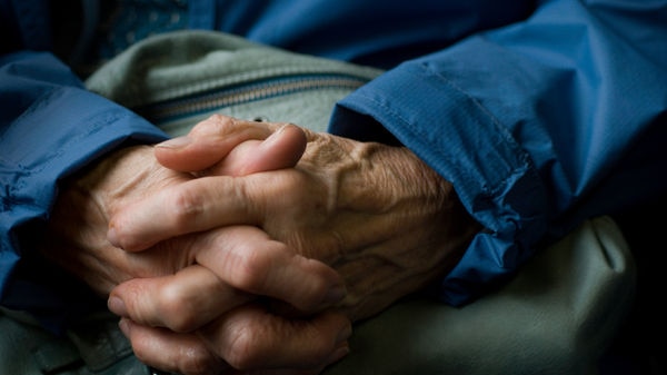 Close shot of an elderly man's hands clasped together.