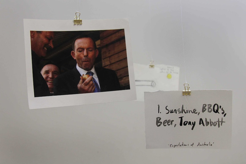 A photo of Tony Abbott eating an onion, and another small placard that reads, 'sunshine, BBQ's, beer, Tony Abbott.'