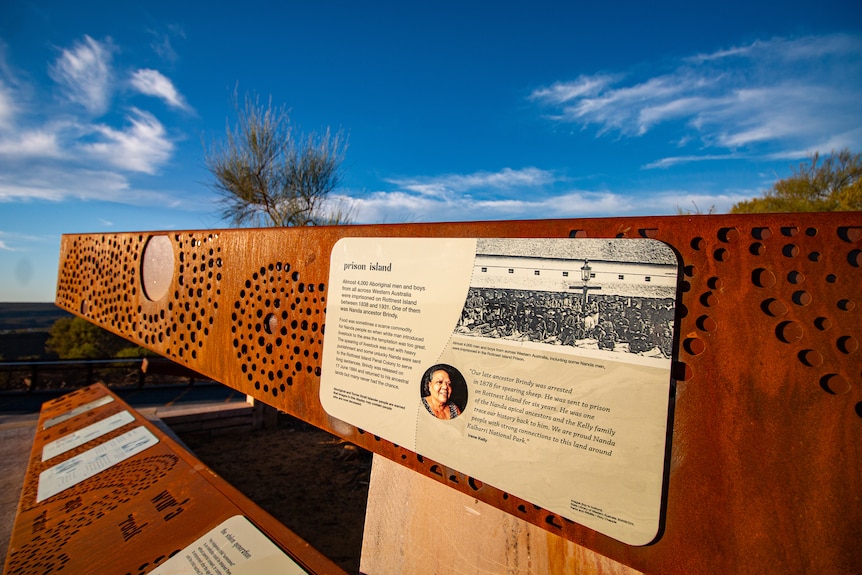 Aboriginal artwork on signs with a blue sky behind