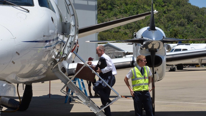 Mr Newman boards a plane at the Cairns Airport.
