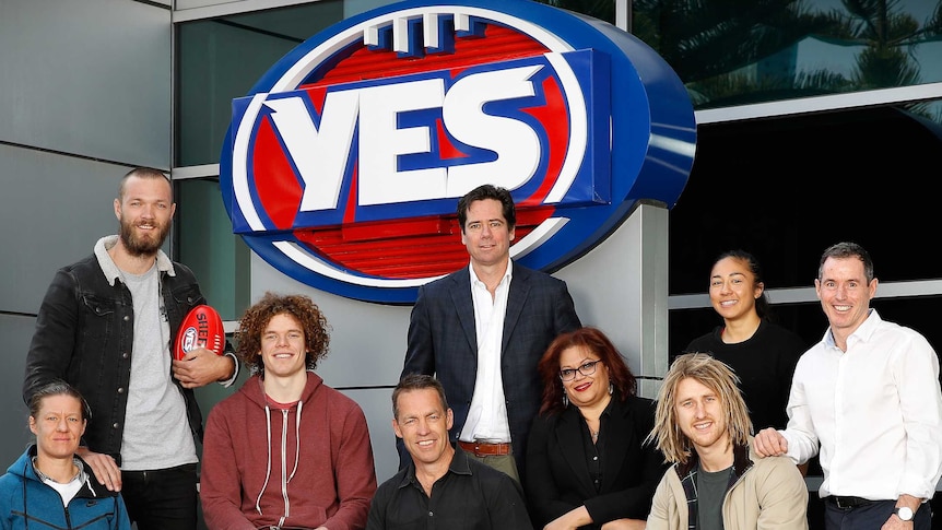 Players and AFL chief Gillon McLachlan stand around AFL's Yes logo, in support of same-sex marriage.