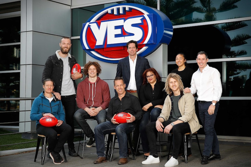 Players and AFL chief Gillon McLachlan stand around AFL's Yes logo, in support of same-sex marriage.