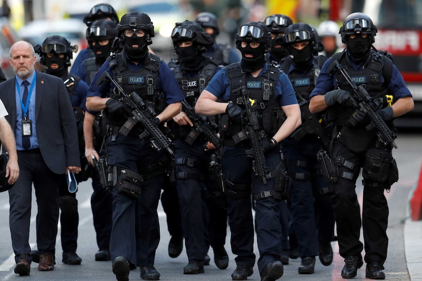 Armed police officers walk outside Borough Market after the attack.