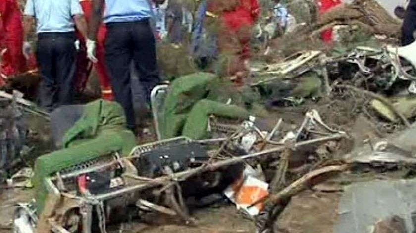 Rescuers sift through the damaged interior of the crashed plane.