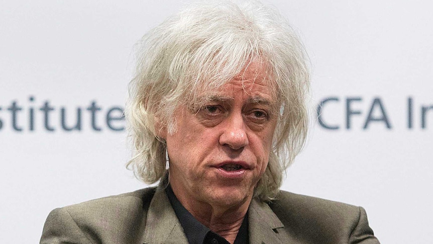 Bob Geldof sits in a chair and speaks.