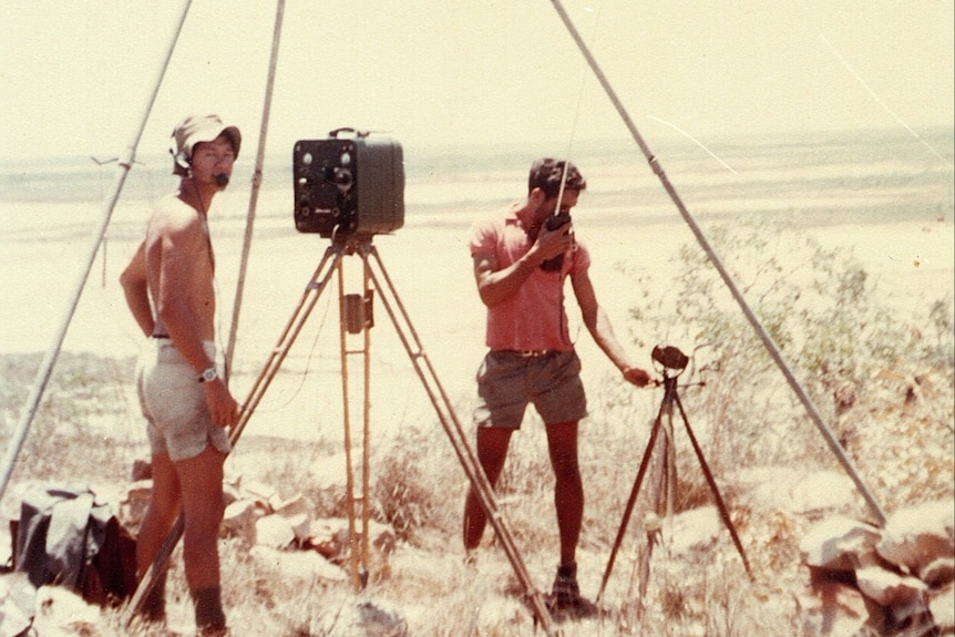 Two men doing survey work in a desert environment.