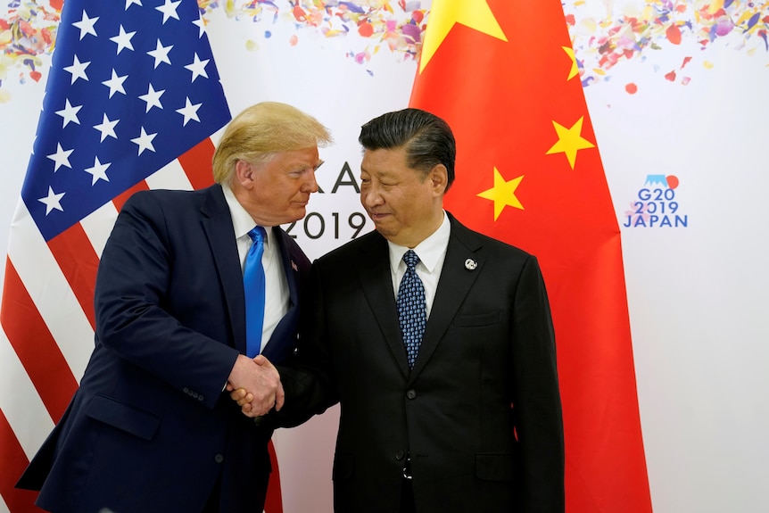 Two men standing and hand-shaking at an event