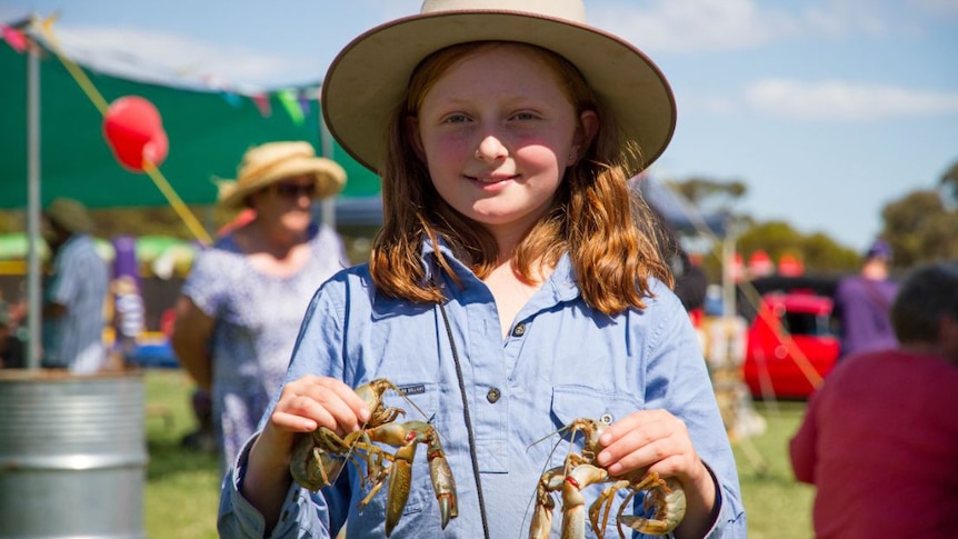 Close up of Zara Guest holding a live yabby in each hand.