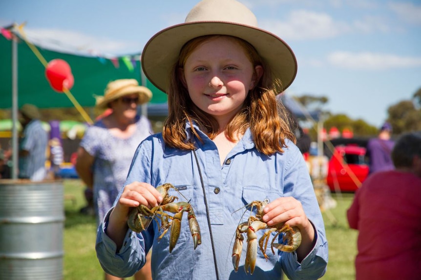 Close up of Zara Guest holding a live yabby in each hand.