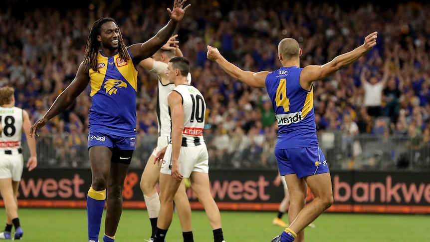 Dom Sheed holds both his arms out and Nic Naitanui moves to high-five him